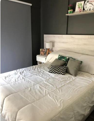 a large white bed with two pillows on it at Ballester city in Villa Ballester
