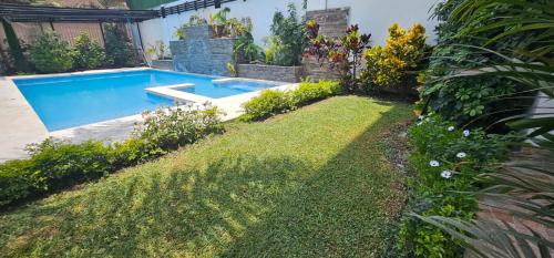 a backyard with a swimming pool and a lawn at Pacharodeo & Hospedaje in Pachacamac