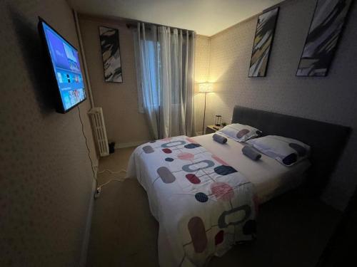 a bedroom with a bed and a flat screen tv at Champions Deluxe in Sarcelles