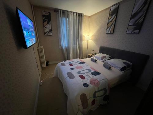 a bedroom with a bed and a flat screen tv at Champions Deluxe in Sarcelles