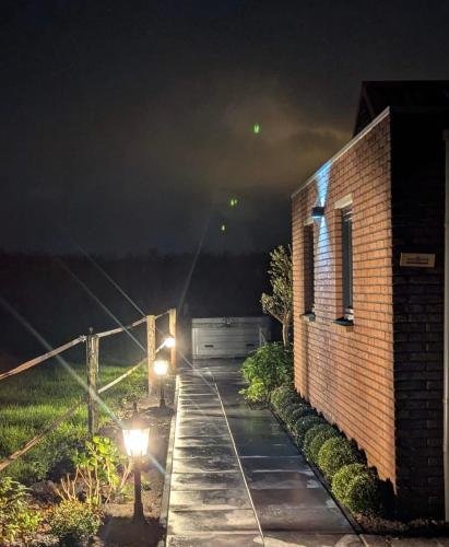 a building with lights on the side of it at night at vakantiehuisje DE WEELEN met Jacuzzi Huwelijks topkeuze! in Lutjebroek