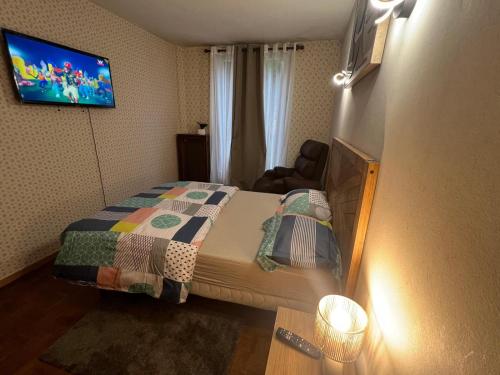 a bedroom with a bed and a tv on the wall at Champions Deluxe in Sarcelles