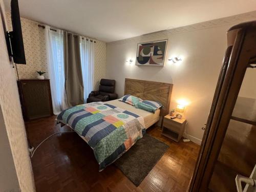 a small bedroom with a bed and a chair at Champions Deluxe in Sarcelles