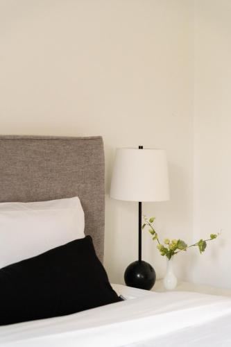 a bedroom with a bed and a lamp at Maison Rasco by Luxury In Transit in Montréal