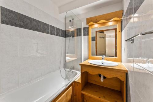 une salle de bain avec un lavabo, une baignoire et un miroir dans l'établissement Résidence Les Hauts De Preclaux - Logement pour 6 personnes aux Orres 1800 MAE-4401, aux Orres