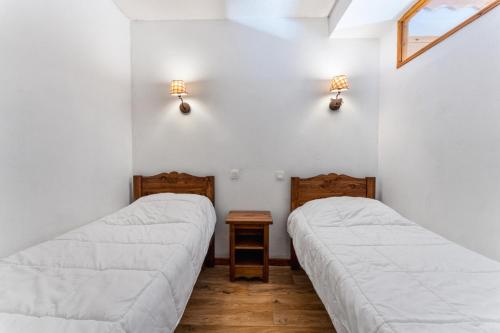 deux lits dans une chambre aux murs blancs dans l'établissement Résidence Les Hauts De Preclaux - Agréable logement pour 6 personnes aux Orres 1800 MAE-9451, aux Orres