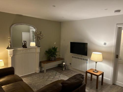 a living room with a couch and a flat screen tv at Williamson House Lancaster in Lancaster