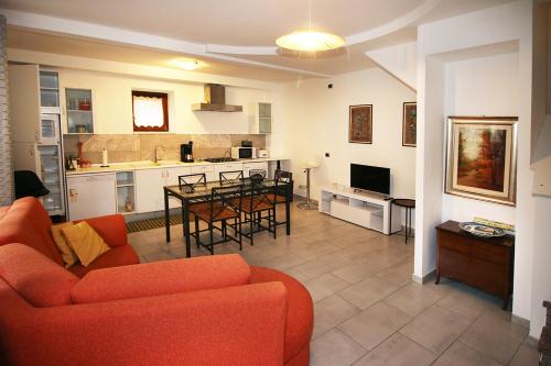 a living room with an orange couch and a kitchen at Casa Boni Ferias in Colico