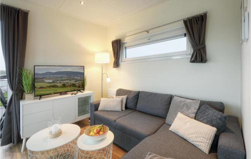 a living room with a couch and a tv at Chalet Sonnenschein in Süsel