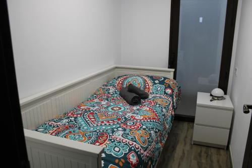 a bedroom with a bed with a colorful comforter at Apartamentos Patas y Patetas in Tragacete