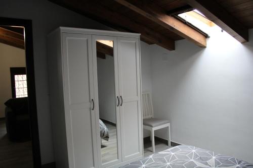a bedroom with a white cabinet with a mirror at Apartamentos Patas y Patetas in Tragacete