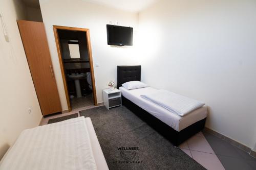 a bedroom with two beds and a tv and a mirror at Heaven Heart - Apartmani Tuzla in Tuzla