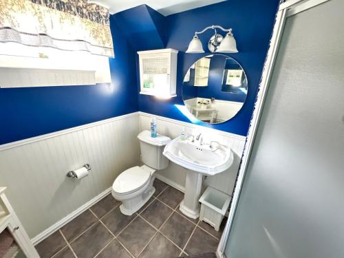 a blue bathroom with a toilet and a sink at Panoramic Lakeview Suite Ultimate Comfort and Serenity in Watchung