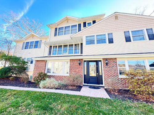 a large white house with a black door at Panoramic Lakeview Suite Ultimate Comfort and Serenity in Watchung