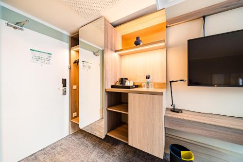 a hotel room with a desk and a flat screen tv at voco Vienna Prater by IHG in Vienna