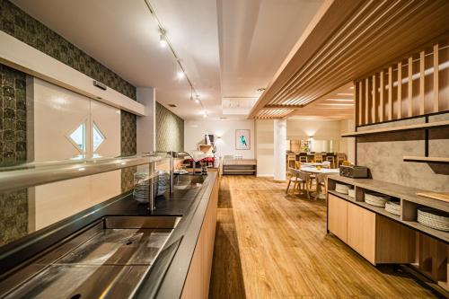 a kitchen with a counter and a dining room at voco Vienna Prater by IHG in Vienna