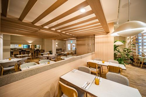 a restaurant with tables and chairs and a cafeteria at voco Vienna Prater by IHG in Vienna