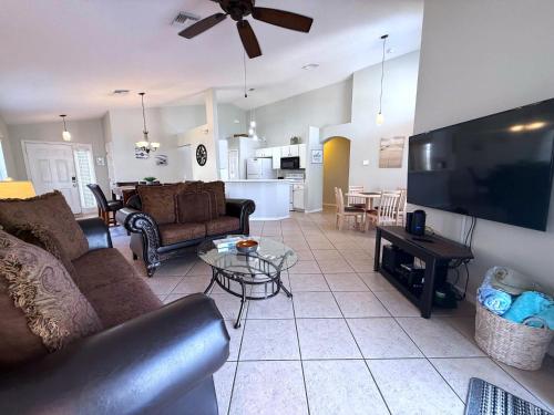 a living room with a couch and a tv at Southern Dunes - Golf Course Views Villa in Haines City