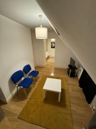 a living room with a white table and blue chairs at Archway Court in London