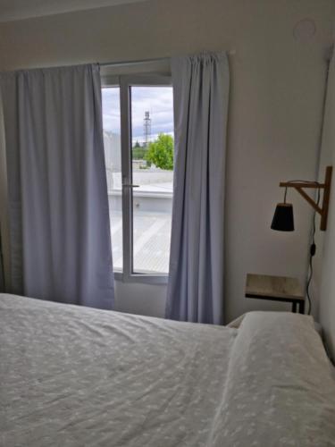 a bedroom with a bed and a window at Apart Origenes 1 in Villa Regina