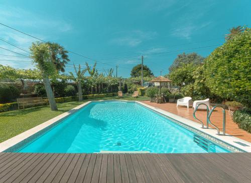 a swimming pool in a yard with a wooden deck at Quinta Sao Miguel de Arcos in Vila do Conde