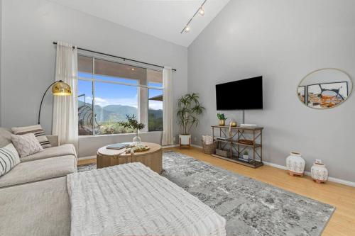 a living room with a couch and a large window at Massive 7BR Stunning MTN View Zen Retreat Pool and Spa in Ramona