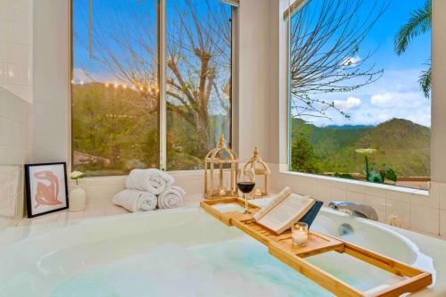 a bath tub in a room with a large window at Massive 7BR Stunning MTN View Zen Retreat Pool and Spa in Ramona