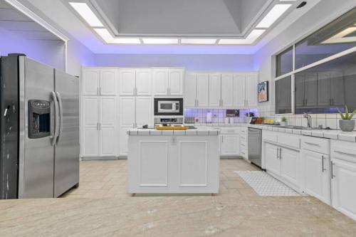 a large kitchen with white cabinets and a refrigerator at Massive 7BR Stunning MTN View Zen Retreat Pool and Spa in Ramona