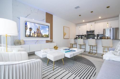 a living room with white furniture and a kitchen at Storey Lake 4BR/3BA Private Pool in Kissimmee