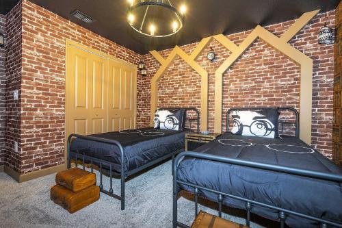 two beds in a room with a brick wall at Storey Lake 4BR/3BA Private Pool in Kissimmee