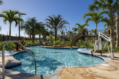 a swimming pool in a resort with palm trees at Storey Lake 4BR/3BA Private Pool in Kissimmee