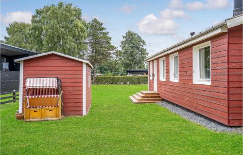 a red building next to a small house at Holiday Home Hejsager Strandby Ix in Kelstrup Strand