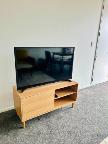 a flat screen tv sitting on a wooden entertainment center at The perfect Christchurch Escape in Christchurch
