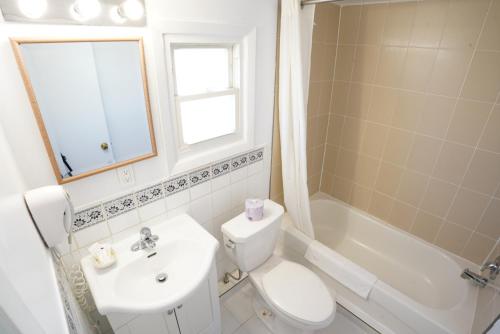 a bathroom with a sink and a toilet and a tub at Falcon Inn in Niagara Falls