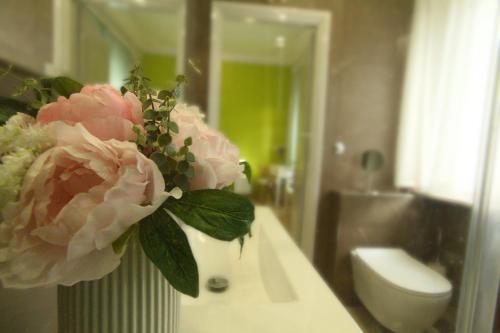 a vase with a flower on a counter in a bathroom at Vivi Lucca con "Madame Fannj" - Camera Verde in Lucca