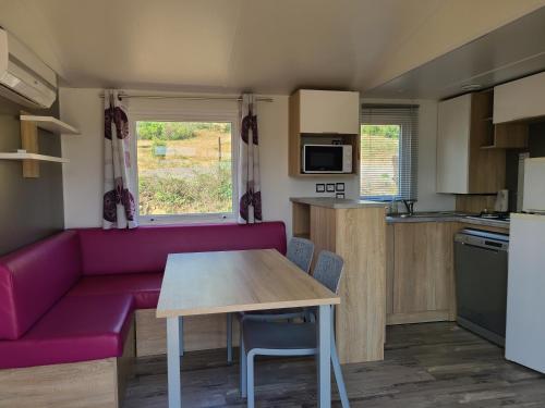 un salon avec un canapé violet et une table dans l'établissement Camping Nysa Paziols, à Paziols