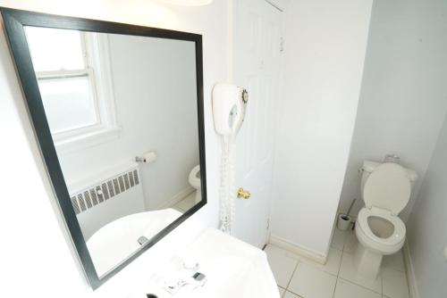 a mirror in a bathroom with a toilet and a sink at Falcon Inn in Niagara Falls