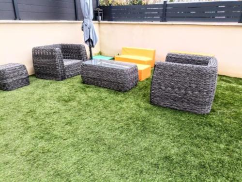 a group of chairs and a table on grass at La chambre des petits voyageurs in Sennecey-lès-Dijon