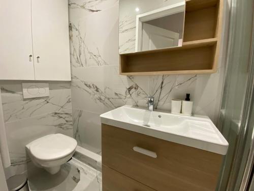 une salle de bain avec un lavabo blanc et des toilettes dans l'établissement Appartement 3p - Vieux village VilleFranche/Mer., à Villefranche-sur-Mer