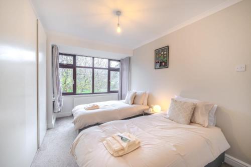a bedroom with two beds and a window at Over Lane in Almondsbury