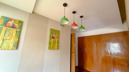 a hallway with two paintings on the walls and a wooden door at House Park Boutique - Casa de Huéspedes in Santa Fe
