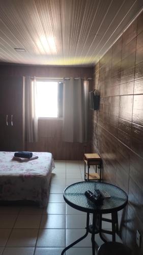 a room with a bed and a table and a window at Ponta Verde CENTRAL in Maceió