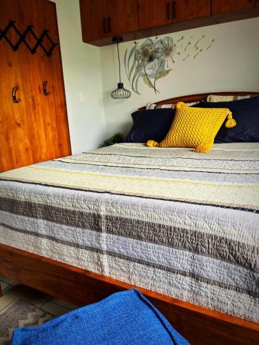 a bed with blue and yellow pillows on it at Designer-inspired 1bed1bath Condo Close To Beach in Coco