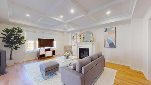 a living room with a couch and a tv at New Custom-built House Close to Rogers Stadium in Toronto