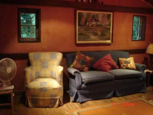 a living room with a couch and a chair at Casa de campo na praia in São Sebastião