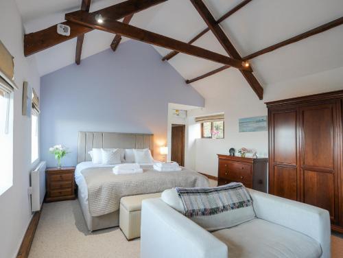 ein großes Schlafzimmer mit einem Bett und einer Couch in der Unterkunft Tai Ffolt in Pwllheli