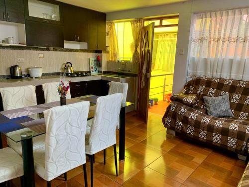 a kitchen and living room with a table and a couch at Cozy and comfy appartment - Puno in Puno