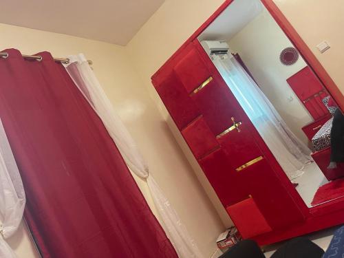 a red cabinet with a mirror in a room at Bienvenue aux portes de ngor - almadies in Ngor