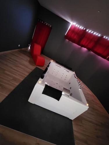 a room with a desk and a red chair at La Suite Romantique in Rethel