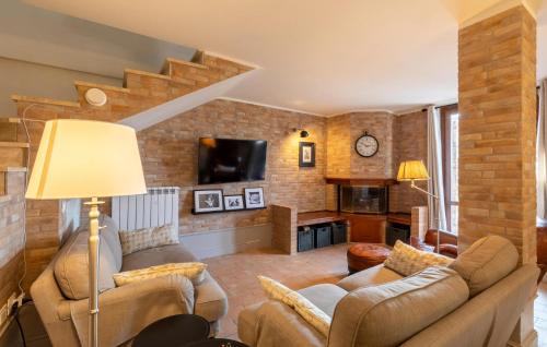a living room with two couches and a brick wall at Lovely Home In Castiglione Del Lago in Castiglione del Lago
